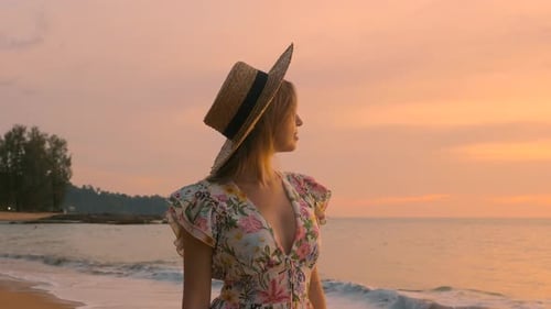 Young Beautiful Woman in Dress Standing on the Island Beach on Summer Pink Sunset