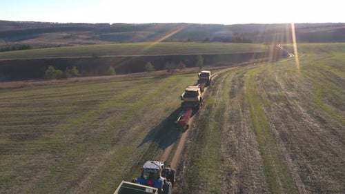 Flying Over Agricultural Machinery Driving on Country Road After Finishing Work on Farmland