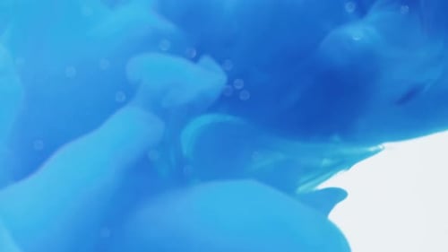 Swirling Blue Ink Spreads on a White Backdrop