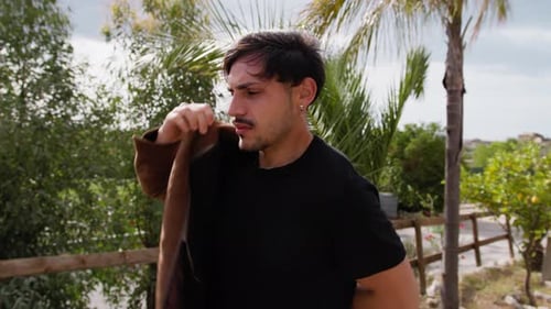 Man Wears Brown Jacket in His Garden