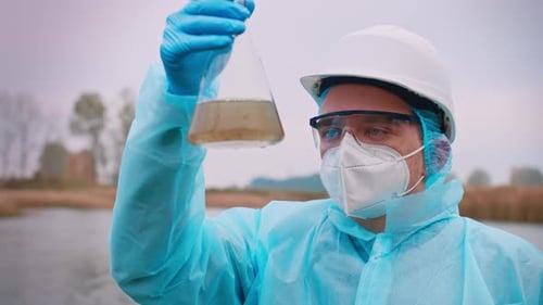 Scientist Inspecting Water Sample by the Lake