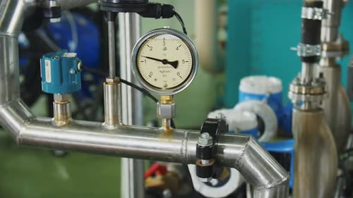 Pressure Meter with Arrow Shows Data on Pipe in Workshop
