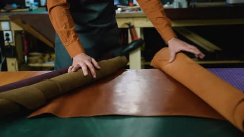 Craftsman Working with Leather Rolls in a Workshop