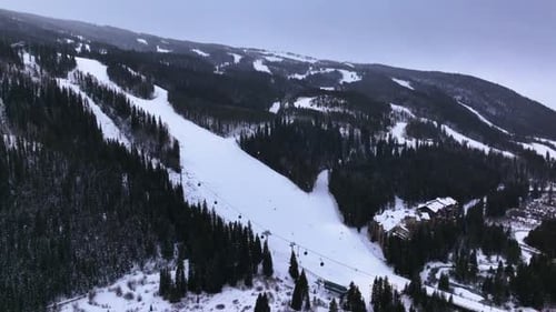 Stunning aerial drone view of massive mountain ski resort and slopes