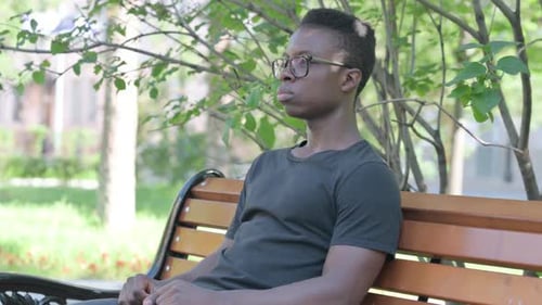 Young Adult Smiling on Park Bench in Sunlight
