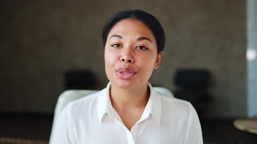Multicultural Female Manager Talking Confidently During Video Call at Office