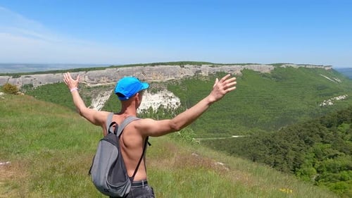 Tourist Carefree Hiker Man Rising Up Hands Standing on Edge of Rocky Mountain
