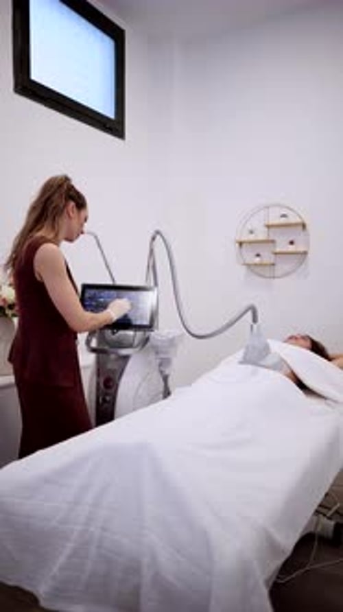 Woman Receives Treatment from Technician with Beauty Machine