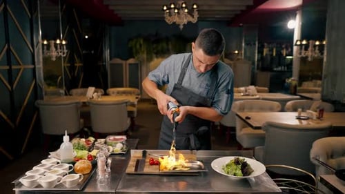The chef of an Italian restaurant uses a gas burner to fry ingredients while preparing a salad