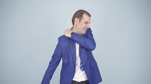 Man in Blazer Rubbing Shoulder in Pain