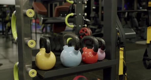 Colorful Kettlebells on a Rack in a Modern Gym