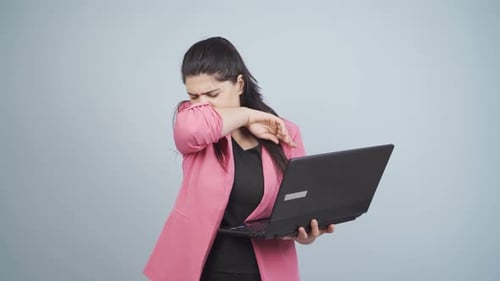 Woman Coughing and Using Laptop Computer