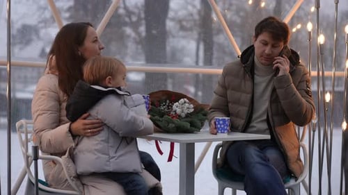 Family Talking on Phone in Winter Dome