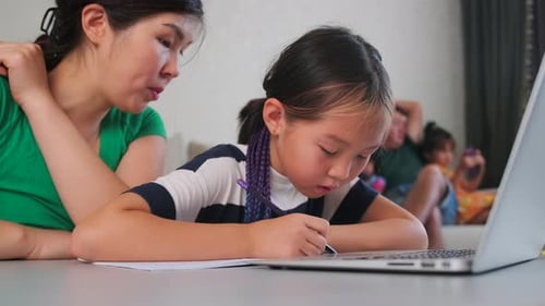 Mother and Daughter Doing Homework at Table