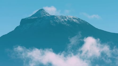 Extreme long lens time-lapse shot of the top of Mount Pico with clouds foreground, the Azores