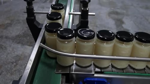 Industrial automated plant production line transparent bottles of goods on conveyor belts in food