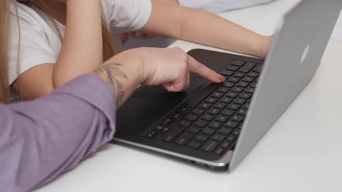 Child Learning to Use Laptop Computer with Adult