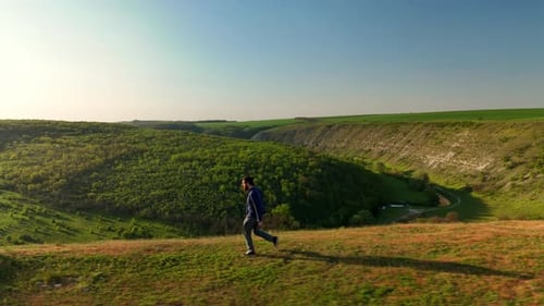 Jogging Along Canyon Edge At Sunset Runner Moving Swiftly Across Open Grassy Terrain