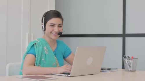 Young Indian Woman with Headset Smiling at Camera in Call Center