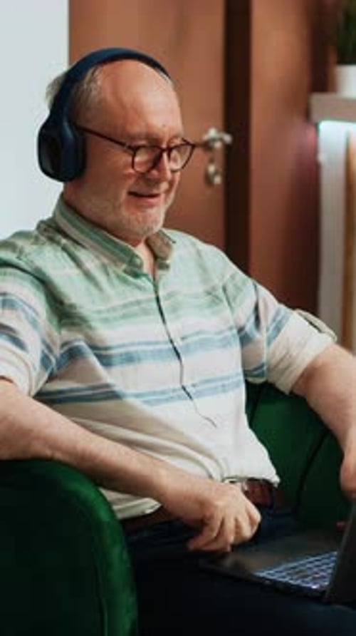 Man with Headphones Using Laptop Indoors