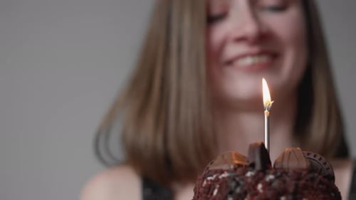 Woman Celebrates Birthday with Chocolate Cake and Candle
