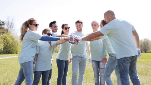 Group of Volunteers Joining Hands in Sunny Park