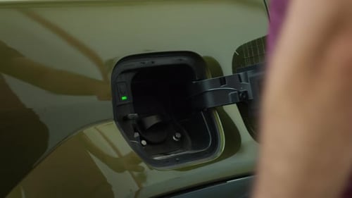Close Up of Driver Recharging Green Technology EV Automobile Battery