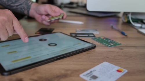 Close up, man using tablet to make payment using bank card. Man hand is typing on tablet
