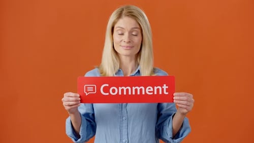 Mujer encantadora que sostiene un póster rojo con un comentario de palabras en el interior