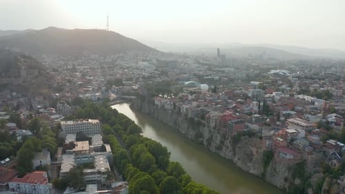 Aerial view of downtown Tbilisi, Georgia at sunset, sunrise with mountains in the background. Forwar