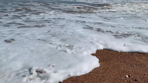 Footprints in the sand washed away by the sea waves at the coast