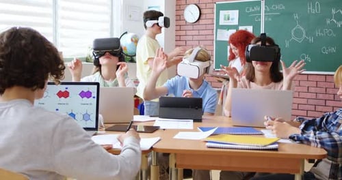 Elementary School Age Children Sitting in VR Glasses and Learning to Use Virtual Reality with Help