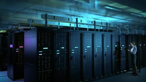 In Data Center: Female IT Technician Running Maintenance Programme on a Laptop, Controls Operationa