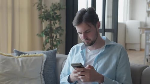 Man Using Mobile Phone While Relaxing on Couch