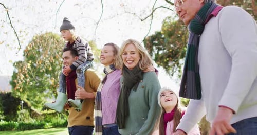 Video of happy caucasian parents walking with son, daughter and grandparents in sunny garden