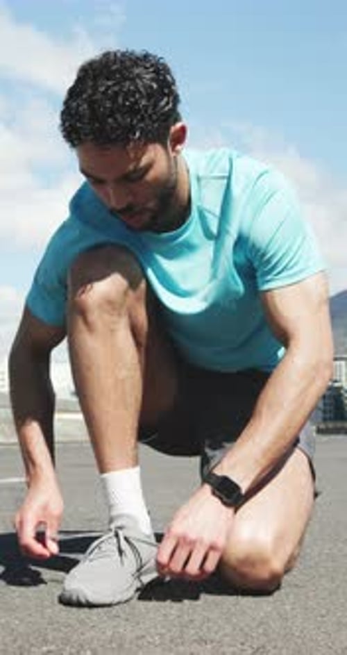Athlete, man and tying shoes on road for getting ready, fitness preparation and exercise