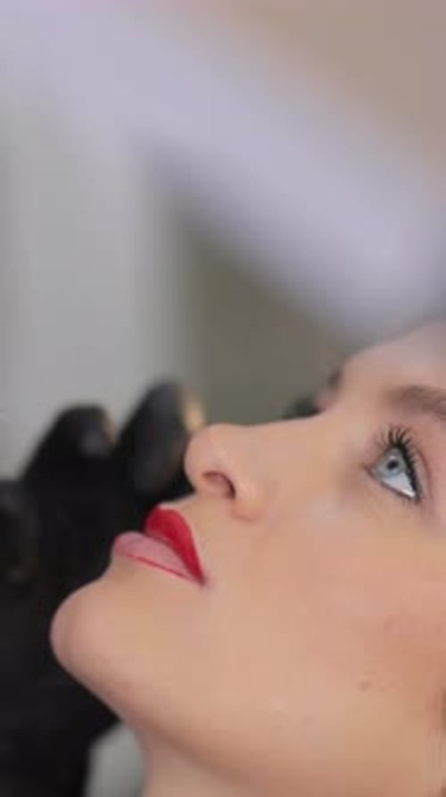 Nahaufnahme einer Frau mit kräftigem Lippenstift und ausdrucksstarken Augen, Schönheitsporträt