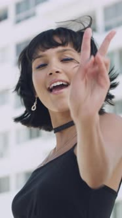 Face, peace sign and kiss with woman in city for flirting, playful attitude or style