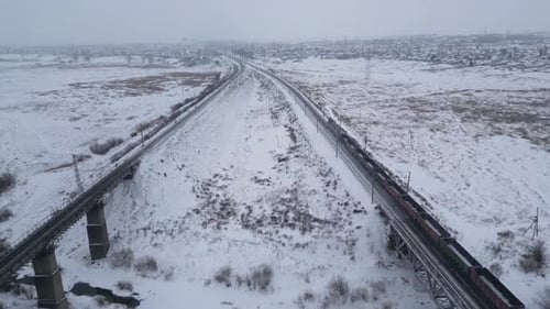 Flight on a Drone Along the Railway and the View of a Moving Train and the Roofs of Freight Cars in