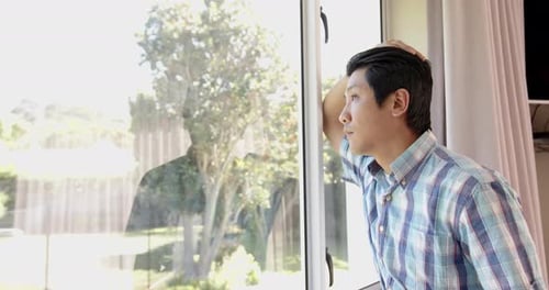 Man Looking Out Window at Home