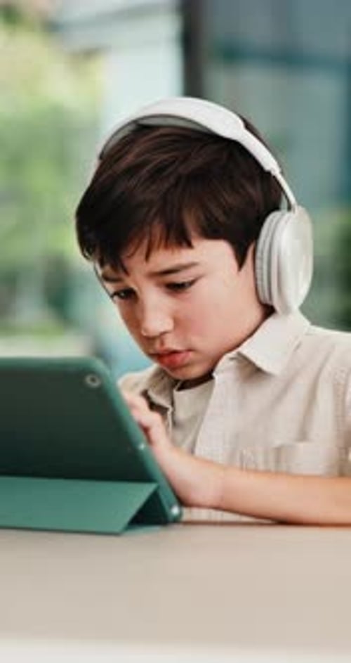 Headphones, tablet and child for e learning, online education and listening to audio in home