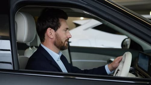 Satisfied Caucasian Business Man Touching Steering Wheel Choosing New Car in Showroom Male