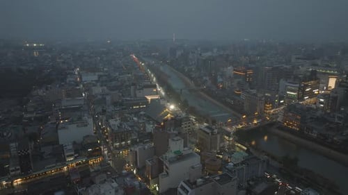 Aufsteigende Luftaufnahmen von Gebäuden und Straßen im Stadtviertel in der Abenddämmerung mit Panoramablick