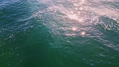 Rippling Ocean Reflecting Sun Beams Close Up. Deep Blue Water Waving Under Sunny Sky Super Slow M...