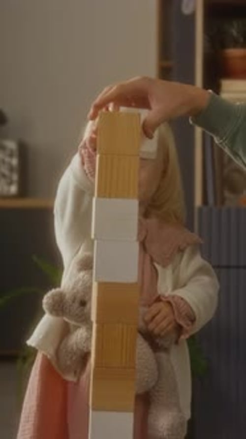 Adorable Girl Building Tower with Wooden Blocks at Home