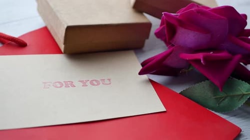 Top View of Gift Box and Rose Flower on Red Background