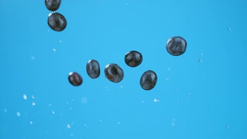 Eight blueberries explosion with water from below, flying in air. High quality cinematic studio comm