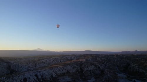 Aerial view of hot air balloons over mountains at sunset, Turkey.