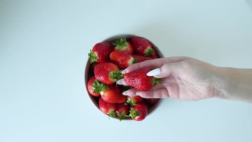 Fresh Strawberries in Bowl Being Picked Up