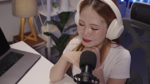 High angle of podcast host leaning in while speaking during live show